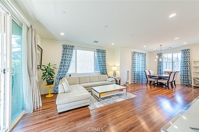 living room with light hardwood / wood-style flooring and an inviting chandelier