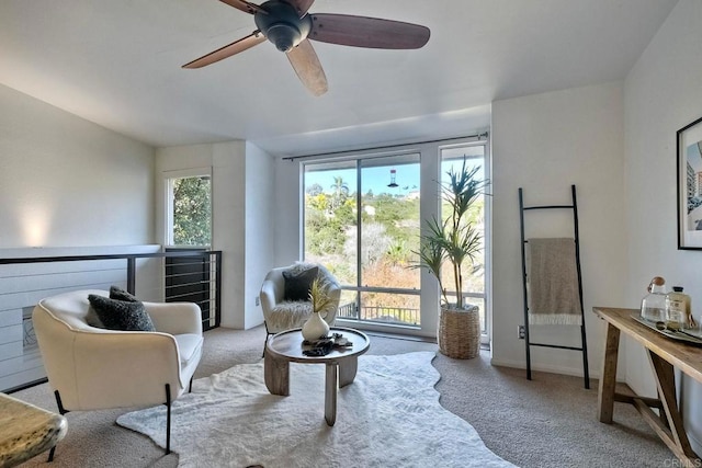 living area with ceiling fan and light carpet