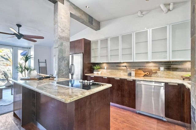 kitchen with appliances with stainless steel finishes, light hardwood / wood-style floors, ceiling fan, dark brown cabinetry, and tasteful backsplash