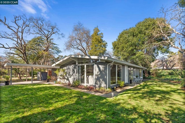 rear view of property featuring a yard and a patio