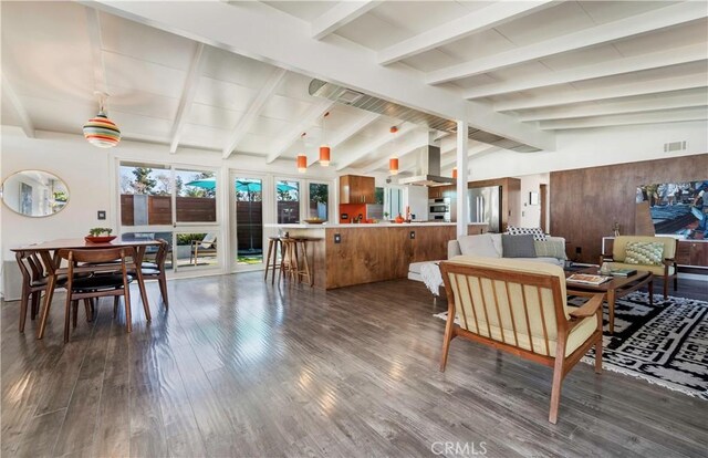 interior space featuring dark wood-type flooring, wooden walls, and vaulted ceiling with beams