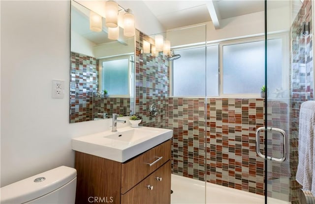 bathroom featuring toilet, backsplash, walk in shower, and vanity