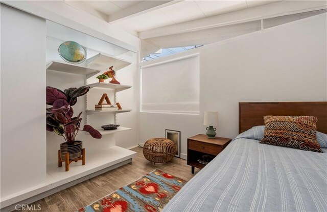 bedroom featuring vaulted ceiling with beams and wood-type flooring