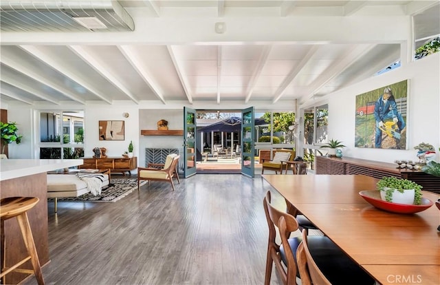 dining area featuring hardwood / wood-style floors, a wealth of natural light, and beamed ceiling