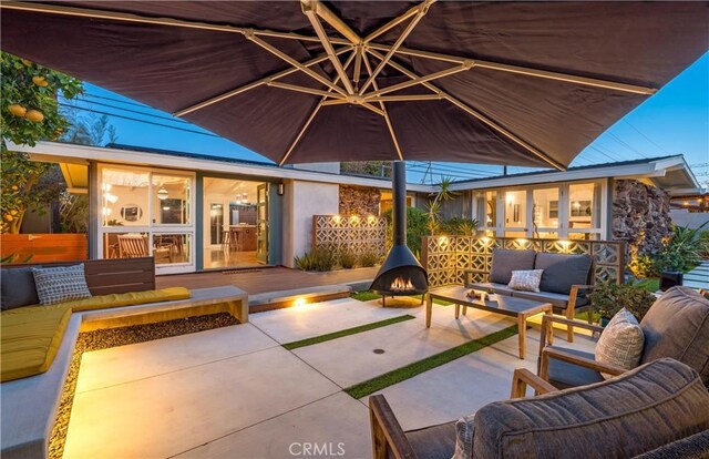 view of patio with an outdoor living space with a fire pit