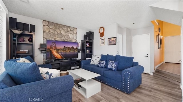 living room with a textured ceiling and light hardwood / wood-style floors