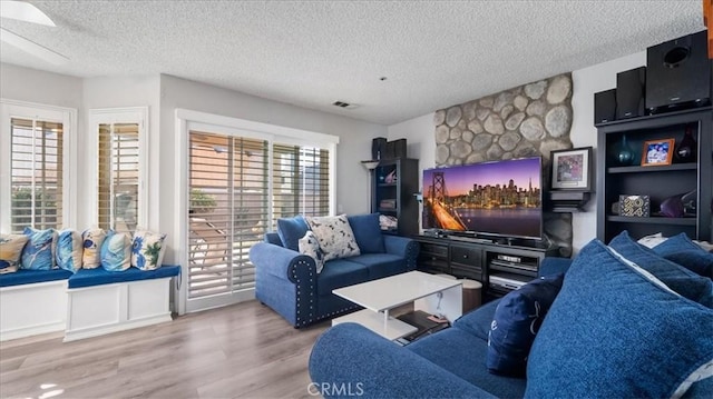 living room with a textured ceiling and wood-type flooring