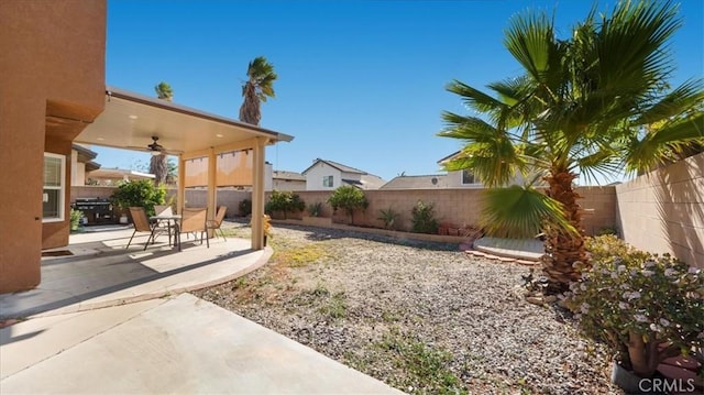 view of yard with ceiling fan and a patio