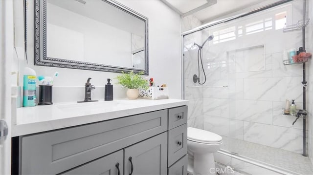 bathroom with an enclosed shower, vanity, and toilet