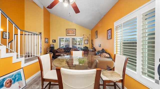 dining room with ceiling fan, lofted ceiling, and wood-type flooring