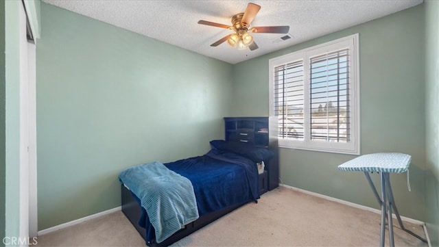 carpeted bedroom featuring a textured ceiling and ceiling fan