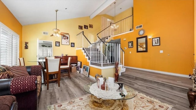 dining room with beamed ceiling, high vaulted ceiling, wood-type flooring, and ceiling fan with notable chandelier