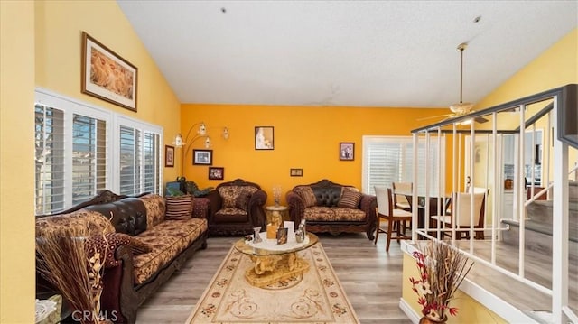 living room featuring plenty of natural light, ceiling fan, vaulted ceiling, and hardwood / wood-style floors