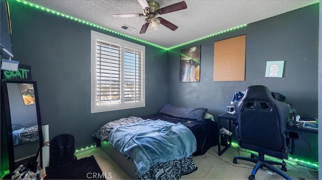 carpeted bedroom with a textured ceiling and ceiling fan