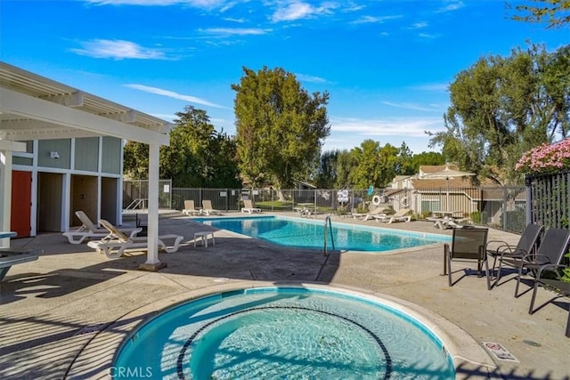 view of swimming pool featuring a community hot tub and a patio area