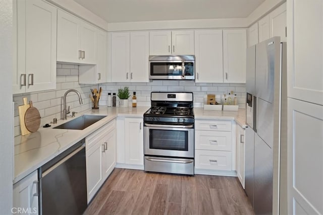 kitchen featuring appliances with stainless steel finishes, white cabinetry, and sink