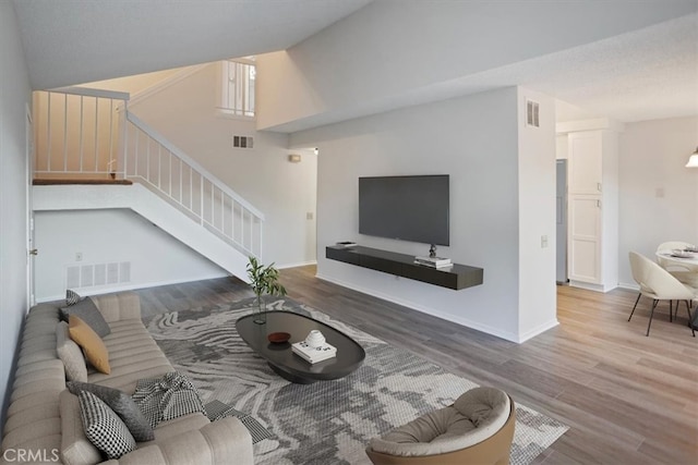 living room with hardwood / wood-style flooring and vaulted ceiling