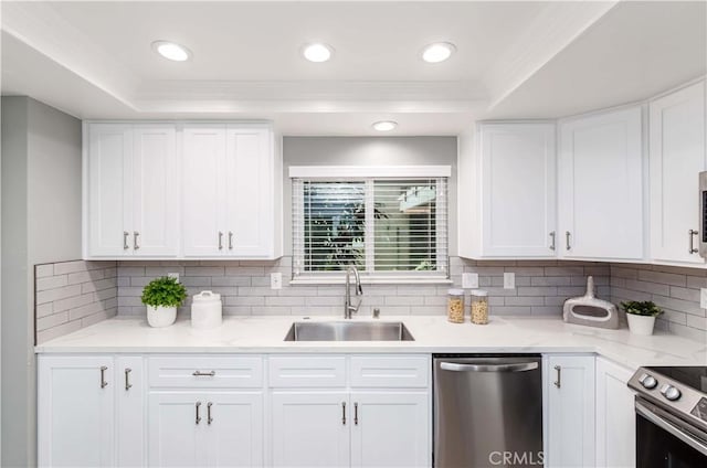 kitchen featuring stainless steel appliances, white cabinetry, sink, and tasteful backsplash