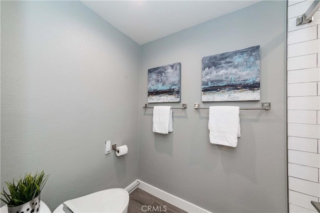 bathroom featuring toilet and wood-type flooring