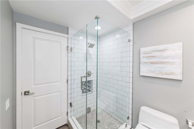 bathroom with crown molding, a shower with shower door, and toilet