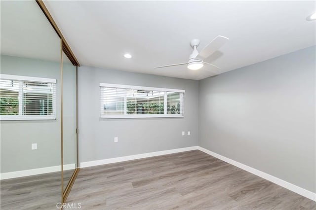 unfurnished bedroom featuring light hardwood / wood-style floors, a closet, and ceiling fan