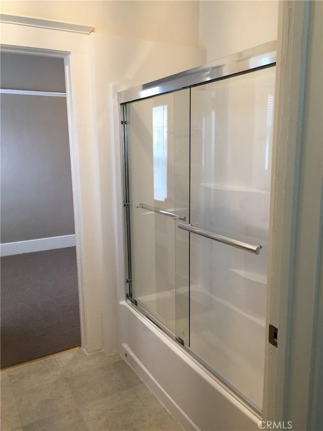 bathroom featuring bath / shower combo with glass door