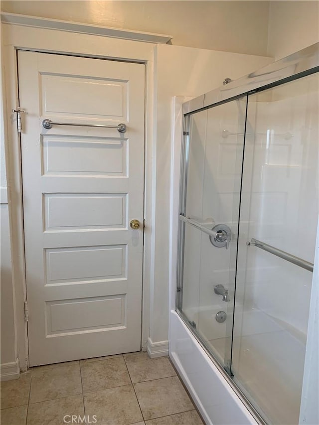 bathroom featuring bath / shower combo with glass door and tile patterned floors