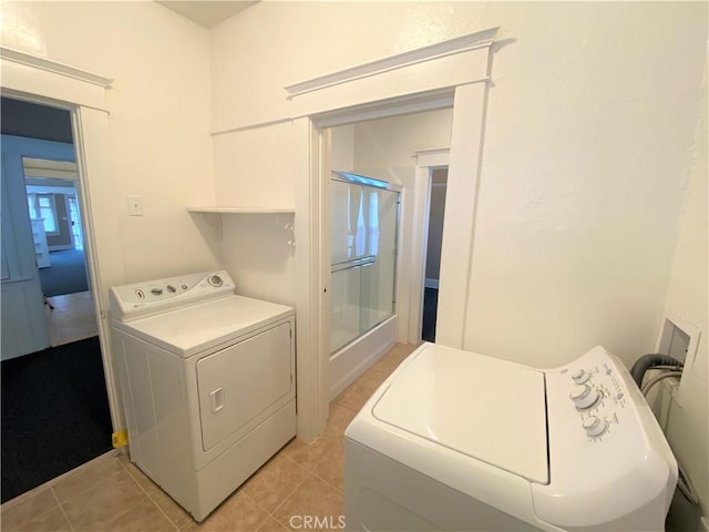 laundry room featuring washing machine and dryer and light tile patterned floors