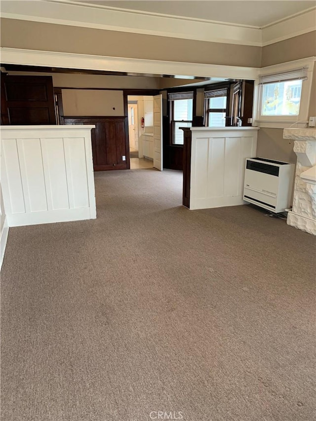 unfurnished living room featuring light colored carpet, heating unit, and a fireplace