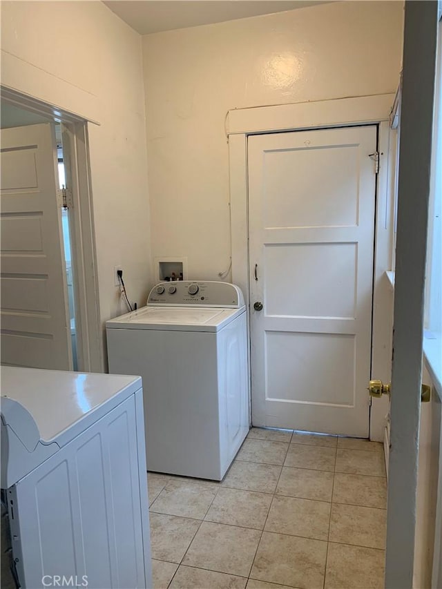 laundry area with washing machine and dryer and light tile patterned flooring