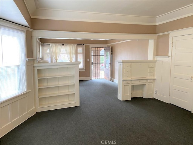 carpeted spare room featuring ornamental molding and plenty of natural light