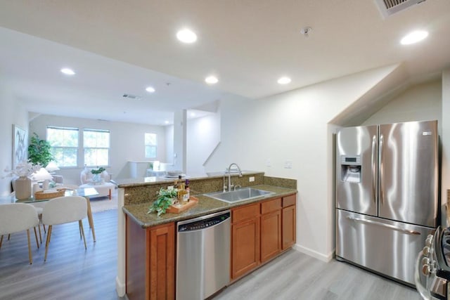 kitchen featuring kitchen peninsula, sink, stainless steel appliances, and light hardwood / wood-style floors