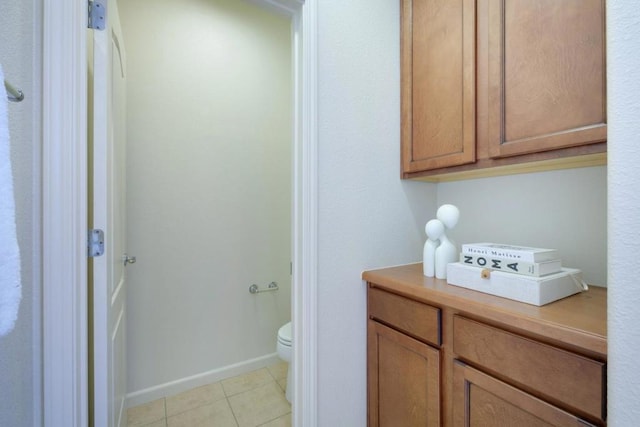 bathroom with toilet and tile patterned flooring