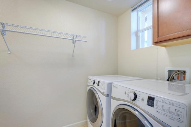 laundry area with independent washer and dryer and cabinets