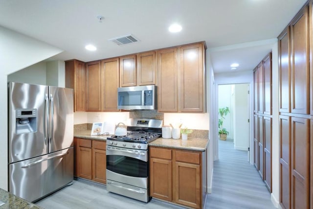 kitchen featuring appliances with stainless steel finishes and light hardwood / wood-style flooring