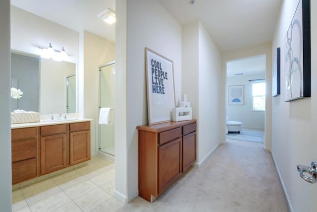 hall with light colored carpet and sink