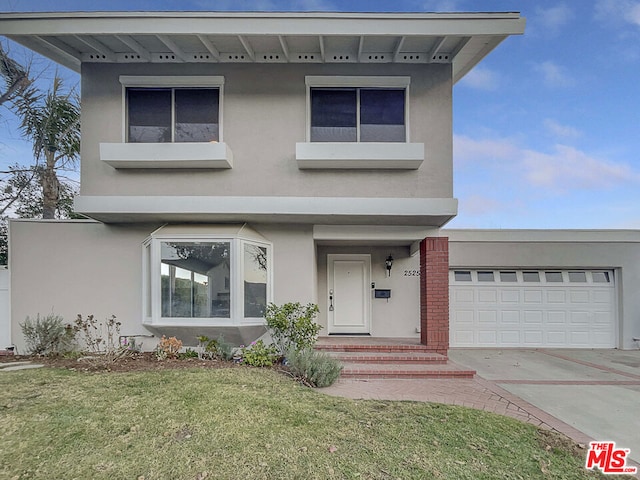 view of front of home featuring a front yard and a garage