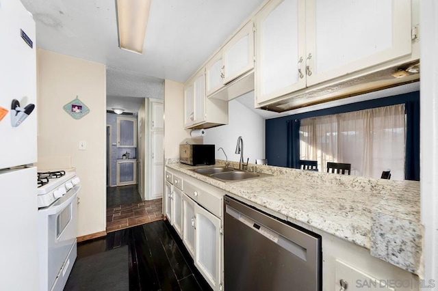 kitchen with white appliances, sink, light stone counters, and white cabinetry