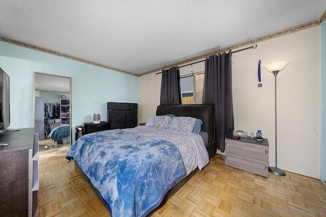 bedroom with a textured ceiling and light parquet floors