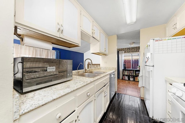 kitchen featuring white cabinets, dishwasher, white range, dark wood-type flooring, and sink