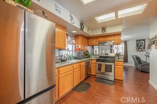 kitchen with sink, stainless steel appliances, and hardwood / wood-style floors