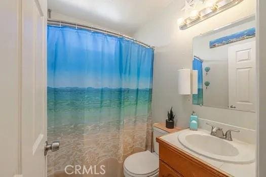 bathroom with a shower with curtain, vanity, and toilet