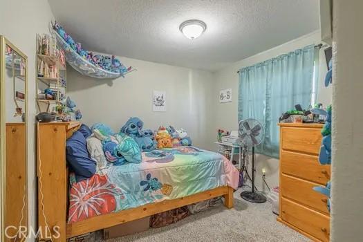 bedroom featuring carpet floors and a textured ceiling