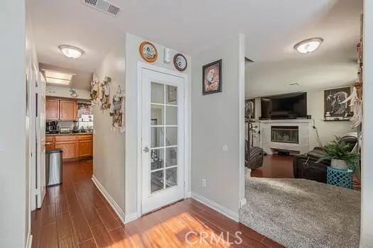 doorway to outside featuring a fireplace and dark hardwood / wood-style flooring