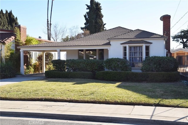 view of front facade featuring a carport and a front yard