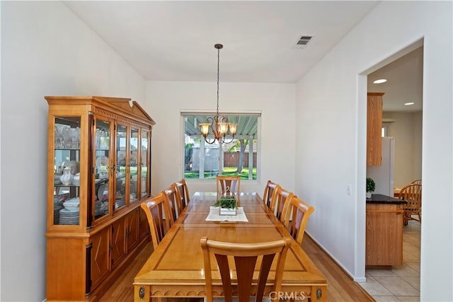 dining area featuring a notable chandelier and light tile patterned flooring