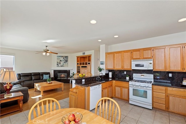 kitchen with white appliances, backsplash, sink, and light tile patterned floors