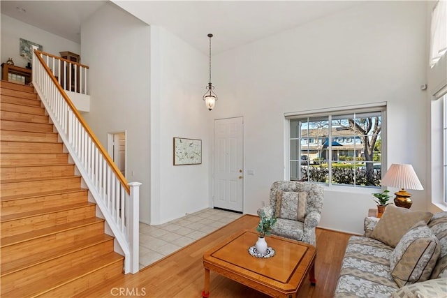 living room featuring a high ceiling and light hardwood / wood-style flooring