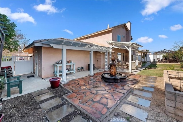 back of property featuring a patio area and a pergola