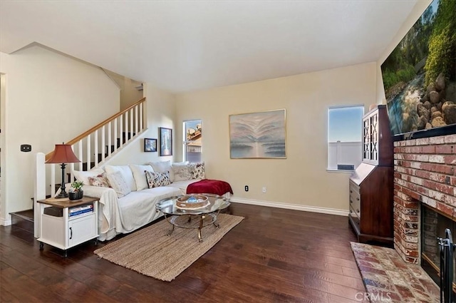 living room featuring a brick fireplace and dark hardwood / wood-style floors